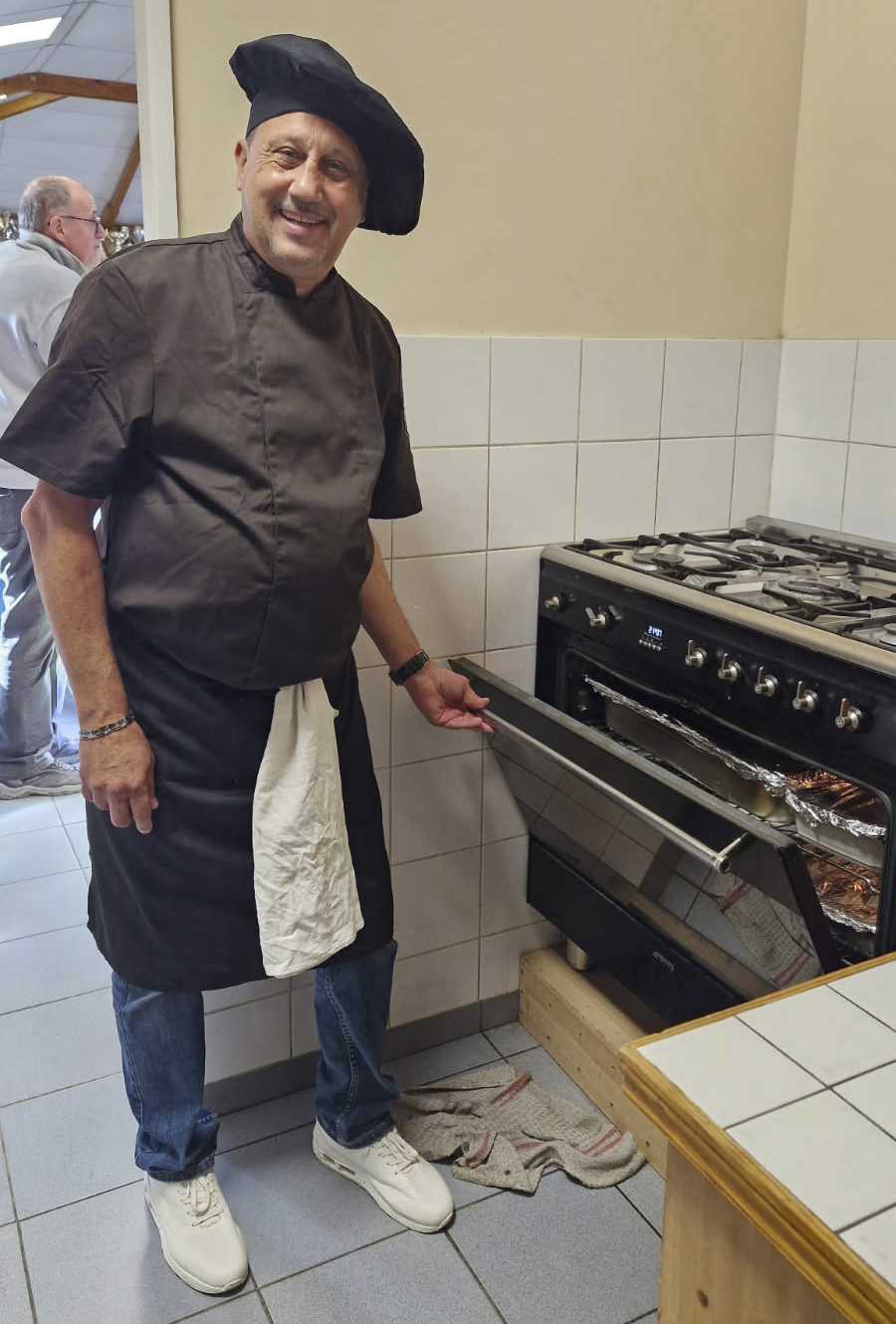 Tommaso tout sourire veille à la cuisson des lasagnes